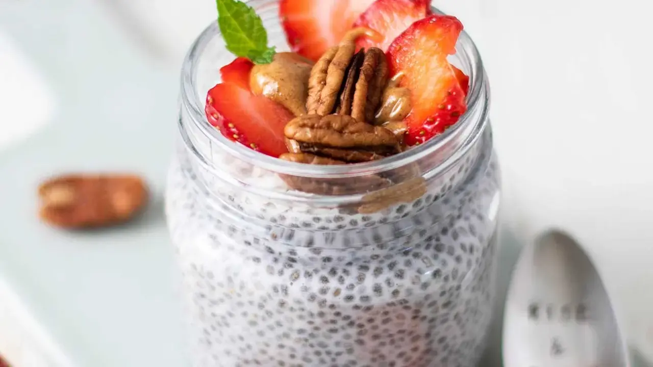 Keto Chia Pudding im Glas mit Erdbeeren, Pekannüssen und Mandelbutter. Ein gesunder Start in den Tag!