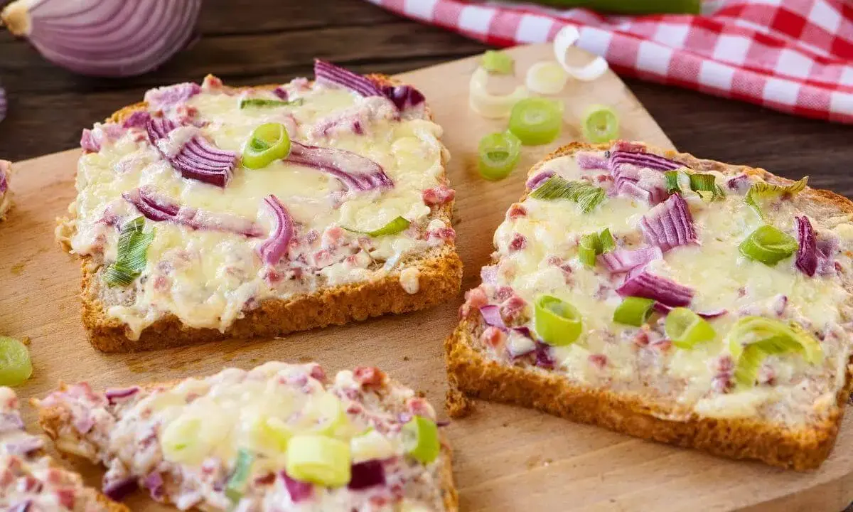 Herzhaft überbackene Brotscheiben mit Käse, roten Zwiebeln und Frühlingszwiebeln. Das sieht nach einem leckeren Abendessen aus! Was esse ich heute abend?