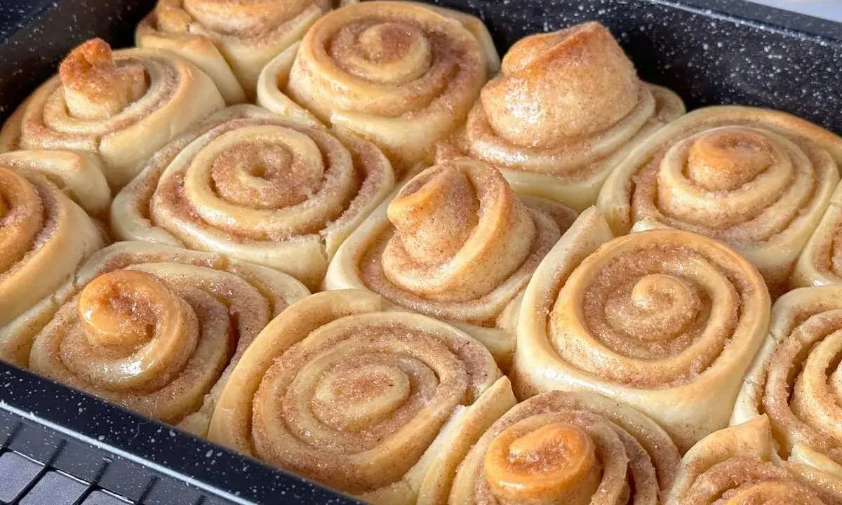 Frisch gebackene Zimtschnecken im Blech, bereit für das Zimtschnecken Rezept. Sie duften nach Zimt und Zucker.