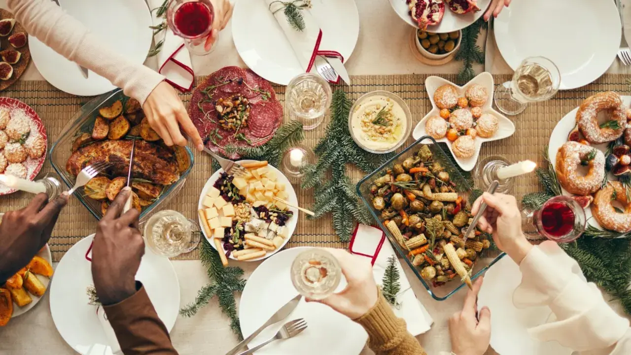 Festliches weihnachtsessen einen tag vorher vorbereiten: Braten, Gemüse, Käseplatte und Gebäck auf dem Tisch.