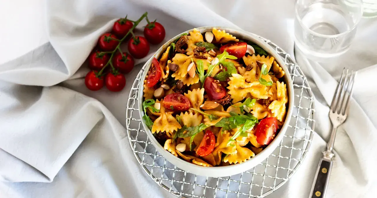 Mediterraner Salat mit getrockneten Tomaten und Rucola, garniert mit Mandeln und frischen Kirschtomaten. Ein leichter Genuss.