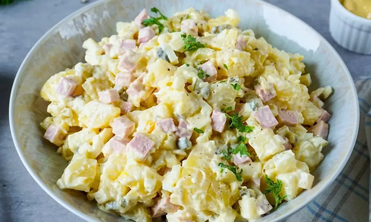 Omas Kartoffelsalat mit Mayonnaise, garniert mit Petersilie. Ein Klassiker, der immer schmeckt!