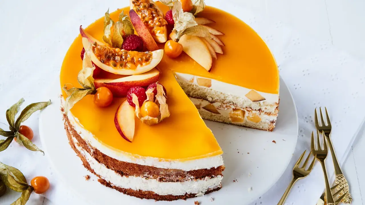 Eine köstliche Pfirsich Maracuja Torte, verziert mit frischen Früchten und Physalis. Ein süßer Genuss für besondere Momente.