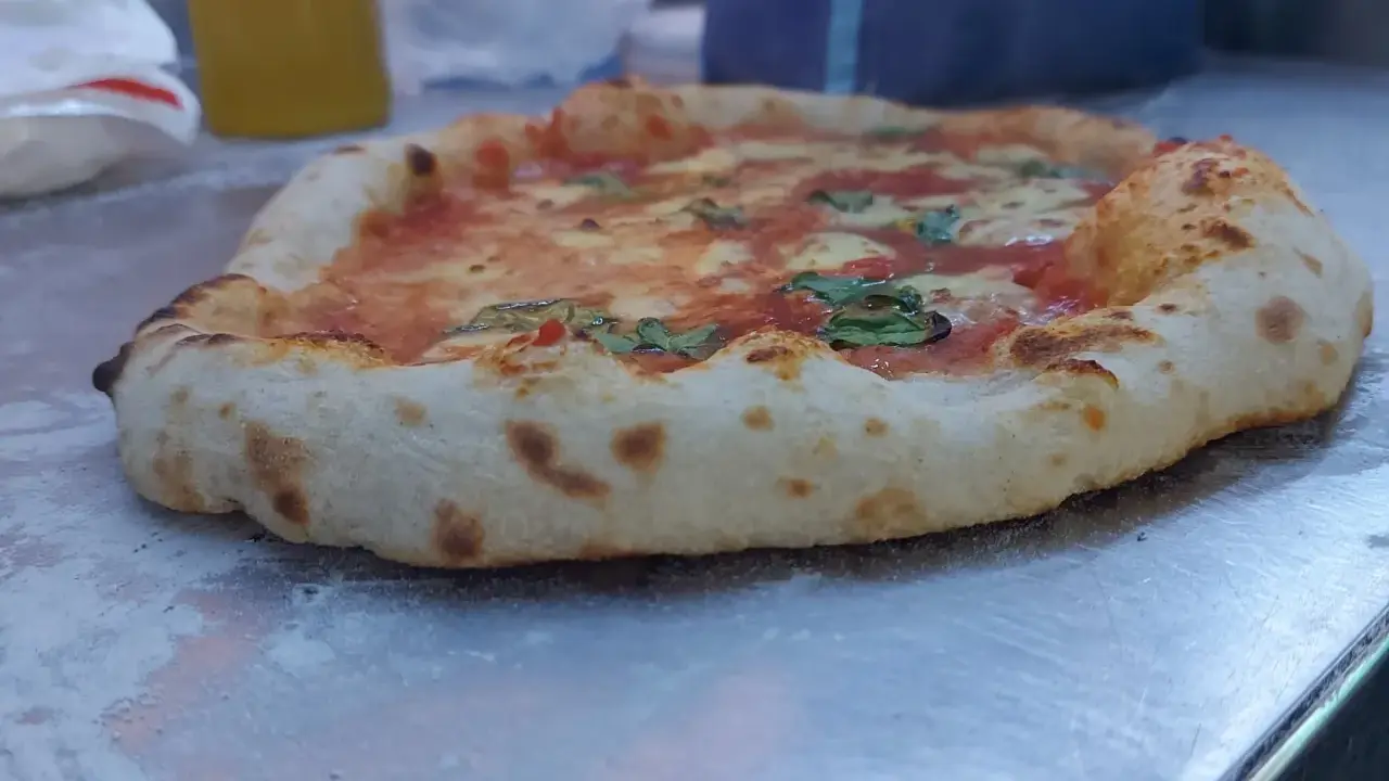 Frisch gebackene Pizza mit weltbestem Pizzateig mit Trockenhefe, belegt mit Tomaten, Mozzarella und Basilikum.