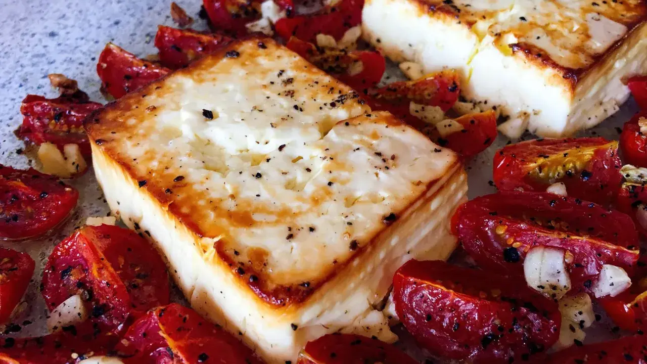 Ofen-gebackener Feta mit Kirschtomaten, Knoblauch und Kräutern. Ein köstliches griechisches Gericht, das im Ofen zubereitet wird.