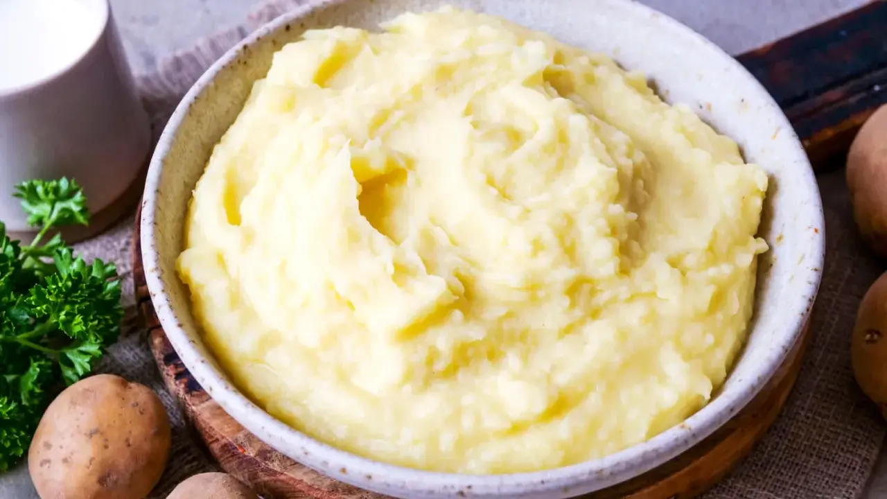 Cremiger Kartoffelbrei, perfekt für ein einfaches Kartoffelbrei Rezept. Dazu ein Krug Milch und frische Petersilie.