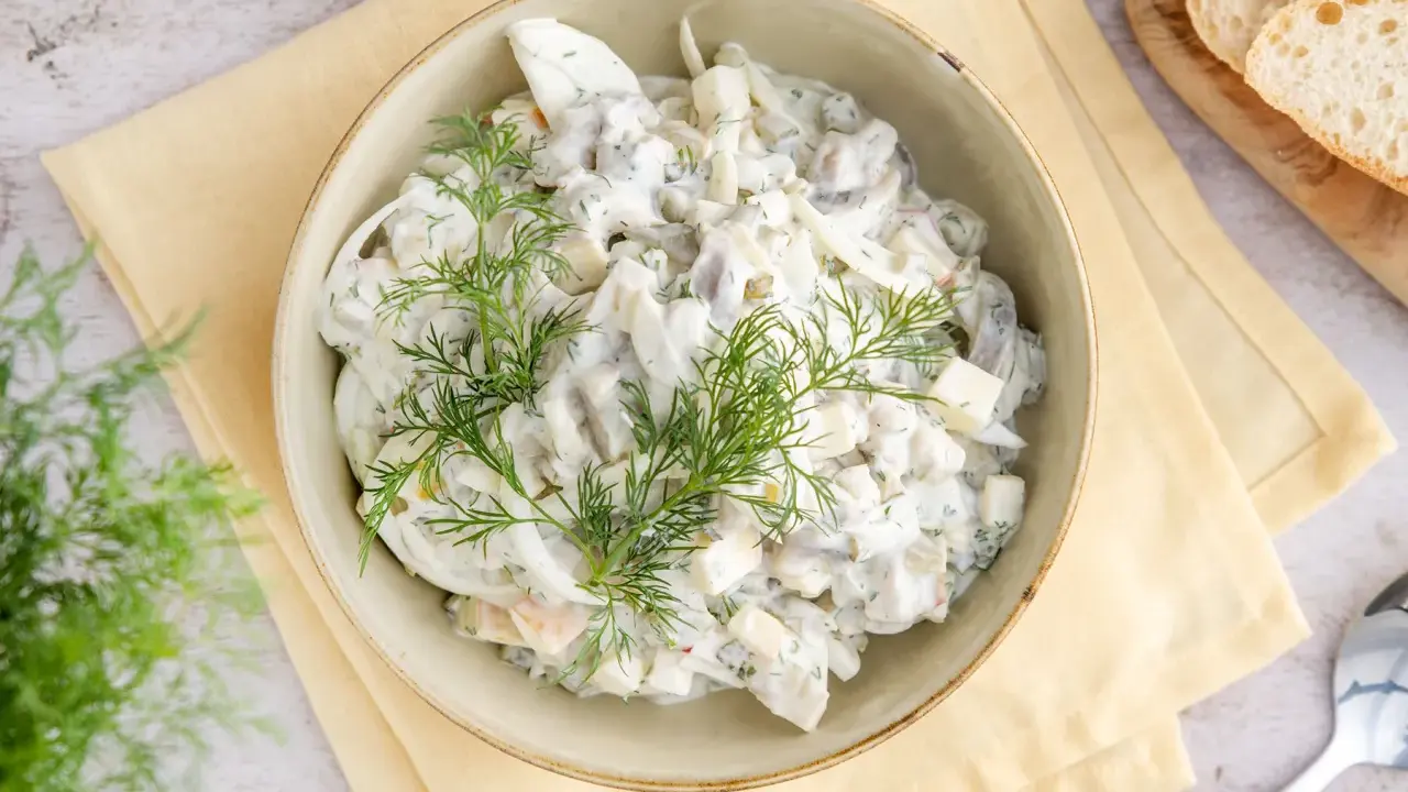 Hausfrauenart Heringssalat, ein cremiges Rezept wie von Oma, garniert mit frischem Dill.