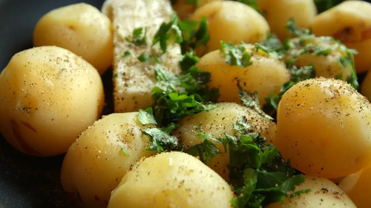 Gekochte Kartoffeln mit Petersilie und Pfeffer. Eine gesunde Beilage, die wenig Kalorien hat.