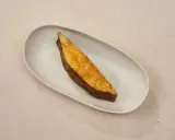 Ein goldbraunes Stück schwarzer Heilbutt liegt auf einer ovalen Schale. Dieser Fisch ist nicht nur lecker, sondern auch gesund.