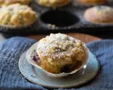 Saftige Blaubeermuffins mit Joghurt und Streuseln, bestäubt mit Puderzucker.