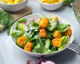 Knuspriger Gnocchi Salat mit Gurke, Salat und Zwiebeln, serviert in einer Schüssel mit einer Gabel.