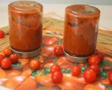 Zwei Gläser mit Tomatensoße, umgeben von frischen Tomaten und Spaghetti. Perfekt für die Tomaten haltbar machen.