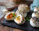 Leckere Onigiri selber machen: Reisbällchen mit Lachsfüllung, umhüllt von schwarzem und weißem Sesam.