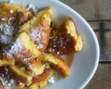 Ein Teller mit goldbraunem Kaiserschmarrn, bestäubt mit Puderzucker. Dieses Kaiserschmarrn Rezept ist ein Genuss!