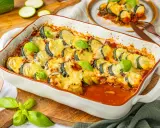 Herzhafter Zucchini Hackfleisch Auflauf mit geschmolzenem Käse und frischem Basilikum, bereit zum Servieren.