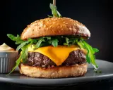 Saftiger Wagyu Burger mit geschmolzenem Käse, Rucola und einer Beilage Sauce. Ein perfektes Wagyu Burger Rezept für Genießer.