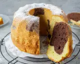 Ein saftiger Marmorkuchen mit Puderzucker bestäubt, ein Stück abgetrennt, das die schöne Marmorierung zeigt.