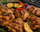 Saftiges pollo fino grillen mit gegrilltem Gemüse, Zitrone und Rosmarin auf einem Teller.