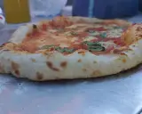 Frisch gebackene Pizza mit weltbestem Pizzateig mit Trockenhefe, belegt mit Tomaten, Mozzarella und Basilikum.