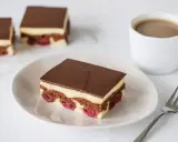 Ein Stück Donauwelle-Kuchen mit Kirschen, Schokolade und Vanillecreme. Perfekt für ein Donauwelle Rezept.