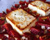 Ofen-gebackener Feta mit Kirschtomaten, Knoblauch und Kräutern. Ein köstliches griechisches Gericht, das im Ofen zubereitet wird.