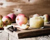 Frische Äpfel und selbstgemachtes Apfelmus im Glas, bereit zum Apfelmus im Backofen einkochen.