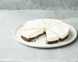Cremiger Kuchen ohne Mehl, in Tortenstücke geschnitten, mit dunklem Boden und heller Füllung, garniert mit Vanillepunkten.