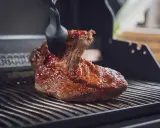 Ein saftiges Brisket, sous vide gegart, wird mit einer BBQ-Sauce auf dem Grill glasiert.