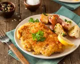 Goldbraunes Schnitzel, perfekt paniert, mit Rosmarinkartoffeln und Zitrone. Die richtige schnitzel panieren reihenfolge macht's!