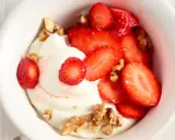Cremiger Skyr mit frischen Erdbeeren und knackigen Walnüssen in einer weißen Schale, ein Genuss für Augen und Gaumen.