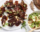 Saftige Spareribs mit BBQ-Sauce und Frühlingszwiebeln, serviert mit einem frischen Salat.