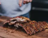 Saftige Rippchen, perfekt gewürzt, liegen auf einem Holzbrett. Ein Countdown läuft: 3, 2, 1... rippchen!