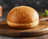 Ein goldbraunes Burgerbrötchen mit Sesam, bereit für das perfekte burger buns rezept.
