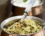 Ein köstlicher Couscous mit Rosinen, Mandelsplittern und frischer Petersilie, serviert in einer Kupferschale.