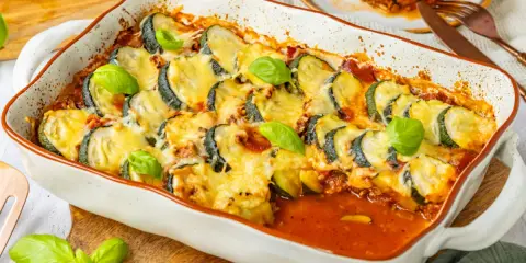 Herzhafter Zucchini Hackfleisch Auflauf mit geschmolzenem Käse und frischem Basilikum, bereit zum Servieren.