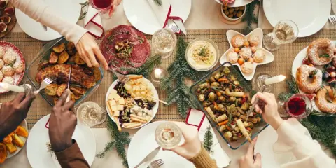 Festliches weihnachtsessen einen tag vorher vorbereiten: Braten, Gemüse, Käseplatte und Gebäck auf dem Tisch.