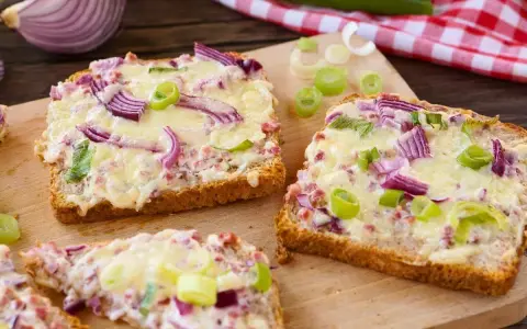 Herzhaft überbackene Brotscheiben mit Käse, roten Zwiebeln und Frühlingszwiebeln. Das sieht nach einem leckeren Abendessen aus! Was esse ich heute abend?