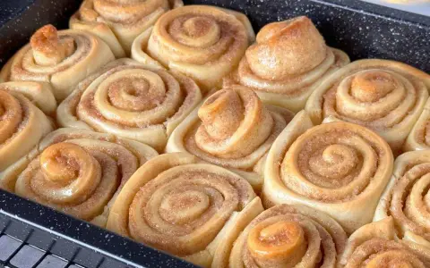 Frisch gebackene Zimtschnecken im Blech, bereit für das Zimtschnecken Rezept. Sie duften nach Zimt und Zucker.