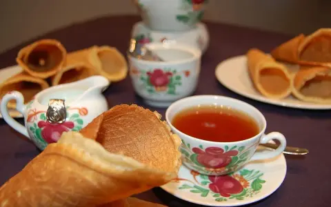 Omas Neujahrskuchen Rezept: knusprige Waffelröllchen mit Tee und Milch.