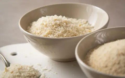 Zwei Schalen mit Paniermehl. Der sichtbare Unterschied zwischen Panko und normalem Paniermehl wird hier deutlich.