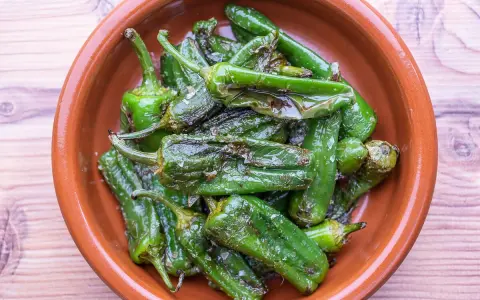 Gebratene Pimientos de Padrón in einer Tonschale, bereit für ein einfaches Rezept.