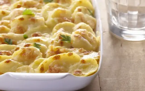 Ein köstliches Kartoffelgratin ohne Sahne, goldbraun gebacken und mit Petersilie garniert. Perfekt für ein leichtes Abendessen.