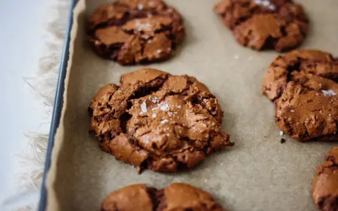 Frisch gebackene, schoko cookies rezept einfach, mit Meersalz bestreut, auf Backpapier.