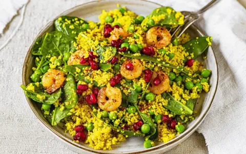 Bunter Couscous-Salat mit Garnelen, Erbsen, Spinat und Granatapfelkernen. Ein leichter und gesunder Genuss.