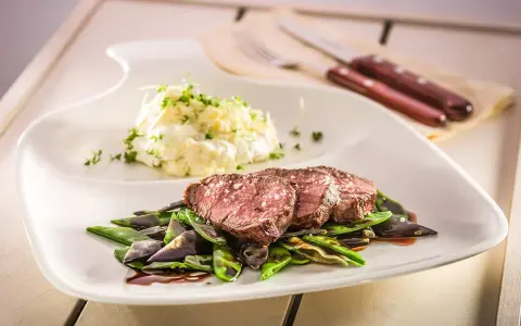 Sternekoch-Qualität: Zartes Kalbsfilet mit knackigen Zuckerschoten und cremigem Kartoffelsalat. Ein Genuss für jeden Gaumen.