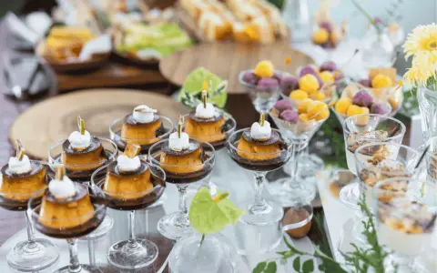 Köstliches Dessertbuffet für eine sommerparty essen 20 personen: Cremige Puddings, bunte Kugeln und süße Leckereien in Gläsern.