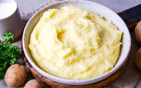 Cremiger Kartoffelbrei, perfekt für ein einfaches Kartoffelbrei Rezept. Dazu ein Krug Milch und frische Petersilie.
