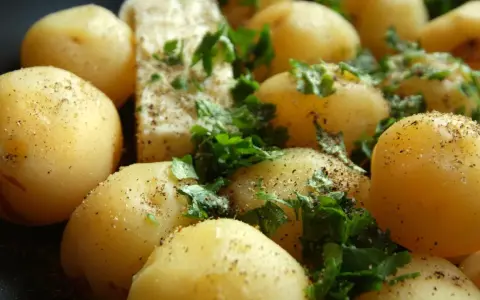 Gekochte Kartoffeln mit Petersilie und Pfeffer. Eine gesunde Beilage, die wenig Kalorien hat.