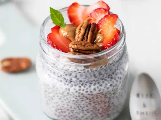 Keto Chia Pudding im Glas mit Erdbeeren, Pekannüssen und Mandelbutter. Ein gesunder Start in den Tag!