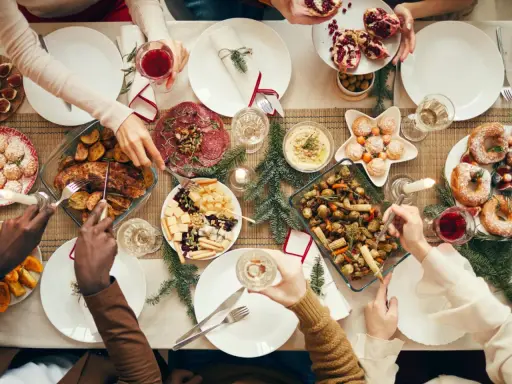 Festliches weihnachtsessen einen tag vorher vorbereiten: Braten, Gemüse, Käseplatte und Gebäck auf dem Tisch.